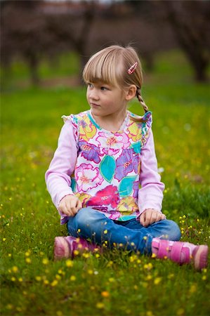 simsearch:400-06768635,k - Cute little girl sitting on a green field with flowers Foto de stock - Royalty-Free Super Valor e Assinatura, Número: 400-05890711