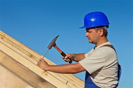 roof hammer - Carpenter working on the roof wooden structure - driving in big nail Stock Photo - Budget Royalty-Free & Subscription, Code: 400-05890758