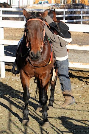 farm fence gate - Young horse rider climbing off his horse Photographie de stock - Aubaine LD & Abonnement, Code: 400-05890825