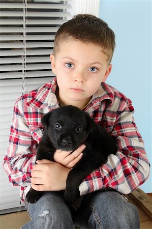 simsearch:400-05890888,k - Beautiful blond boy with a black puppy Foto de stock - Royalty-Free Super Valor e Assinatura, Número: 400-05890887