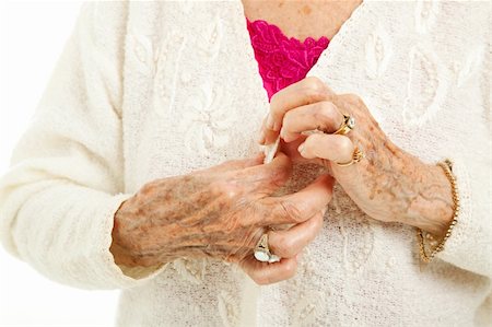 rheumatoid arthritis - Senior woman's arthritic hands struggling to button her sweater. Stock Photo - Budget Royalty-Free & Subscription, Code: 400-05890985
