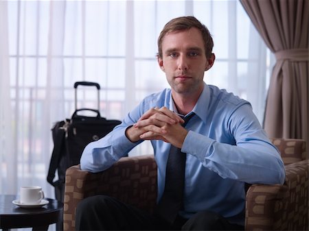 simsearch:6113-07731678,k - Portrait of happy caucasian businessman with crossed fingers smiling at camera in hotel room during business trip. Front view Photographie de stock - Aubaine LD & Abonnement, Code: 400-05891635