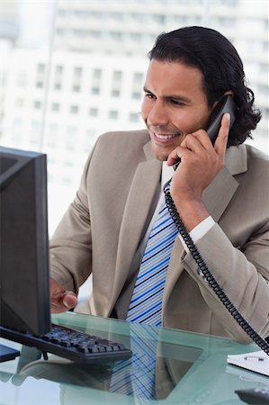 simsearch:400-05900712,k - Portrait of a businessman working with a monitor while being on the phone in his office Stock Photo - Budget Royalty-Free & Subscription, Code: 400-05892342