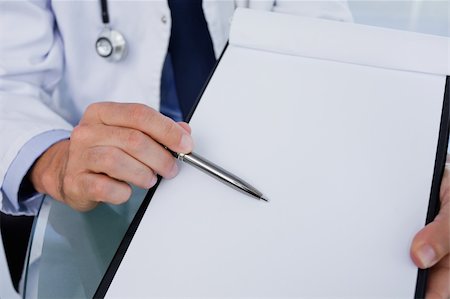 empty doctors uniform - Close up of a male doctor showing a blank document in an office Stock Photo - Budget Royalty-Free & Subscription, Code: 400-05892394