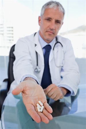 simsearch:400-07099832,k - Portrait of a doctor showing pills in his office Stock Photo - Budget Royalty-Free & Subscription, Code: 400-05892400