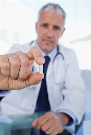 simsearch:400-07099832,k - Portrait of a doctor showing a pill in his office Stock Photo - Budget Royalty-Free & Subscription, Code: 400-05892401