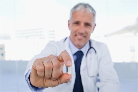 pharmacist (male) - Doctor showing a pill in his office Stock Photo - Budget Royalty-Free & Subscription, Code: 400-05892402