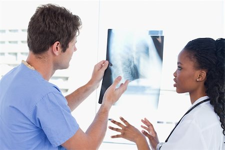 Young doctors looking at a of X-ray in an office Stock Photo - Budget Royalty-Free & Subscription, Code: 400-05892448