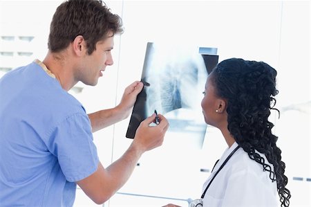 Happy doctors looking at a of X-ray in an office Stock Photo - Budget Royalty-Free & Subscription, Code: 400-05892449