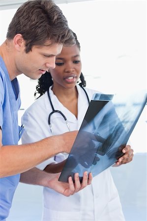 Portrait of serious doctors looking at a of X-ray in an office Stock Photo - Budget Royalty-Free & Subscription, Code: 400-05892441
