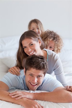simsearch:400-04192370,k - Portrait of a happy family lying on each other in a bedroom Stock Photo - Budget Royalty-Free & Subscription, Code: 400-05892994