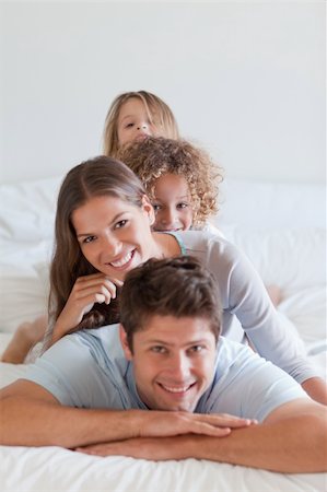 simsearch:400-04193152,k - Portrait of a family lying on each other in a bedroom Stockbilder - Microstock & Abonnement, Bildnummer: 400-05892992
