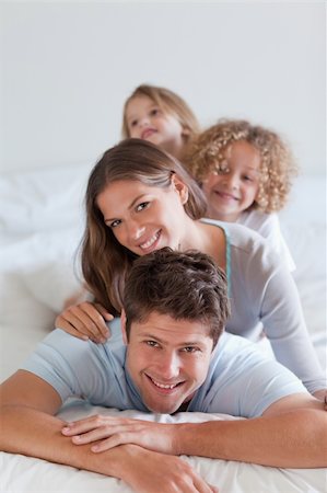 simsearch:400-04193152,k - Portrait of a joyful family lying on each other in a bedroom Stockbilder - Microstock & Abonnement, Bildnummer: 400-05892993