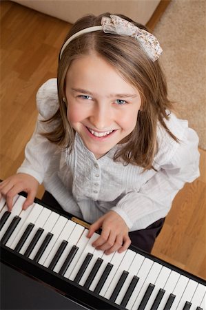 piano practice - Photo of a happy young girl playing the piano at home. Stock Photo - Budget Royalty-Free & Subscription, Code: 400-05893602