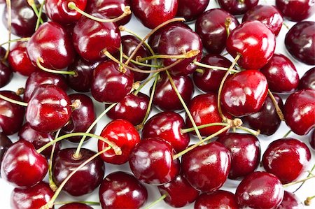 simsearch:400-06921455,k - Red ripe cherries laid on white table Foto de stock - Super Valor sin royalties y Suscripción, Código: 400-05893853
