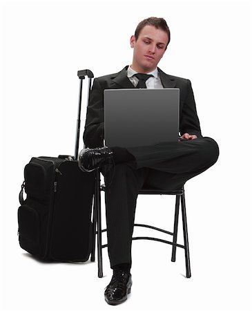 Young traveler businessman working on a laptop next to his suitcase. Stock Photo - Budget Royalty-Free & Subscription, Code: 400-05904671