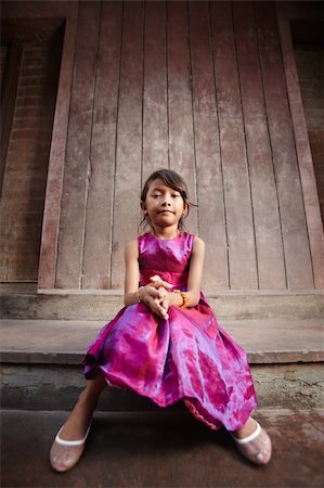 Portrait of cute Asian female child in pink dress looking at camera Foto de stock - Super Valor sin royalties y Suscripción, Código: 400-05905331