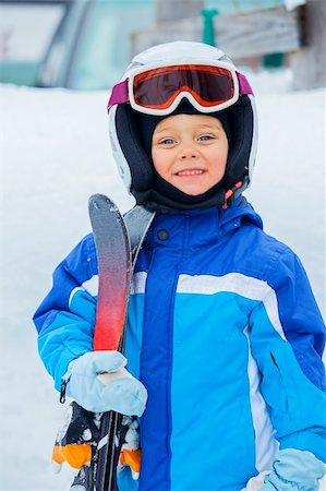 A photo of a Junior skier. Little cute boy with skis and a ski outfit. Vertical view Foto de stock - Super Valor sin royalties y Suscripción, Código: 400-05905743