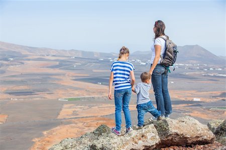 simsearch:400-08035788,k - Young mother with backpack and her chid standing on cliff's edge and looking to a sky Fotografie stock - Microstock e Abbonamento, Codice: 400-05905796