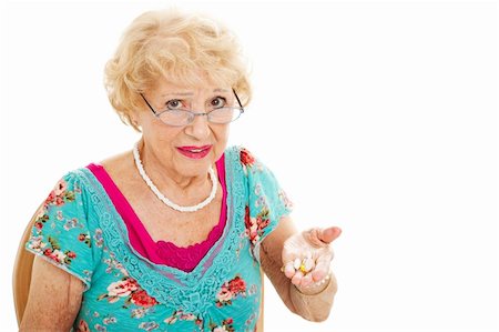 simsearch:400-06333333,k - Senior woman holding a handful of pills and unhappy about taking them.  Isolated on white. Foto de stock - Super Valor sin royalties y Suscripción, Código: 400-05906331