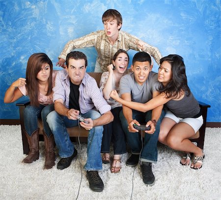 fighting friends on couch - Diverse group of young people fight over video games Stock Photo - Budget Royalty-Free & Subscription, Code: 400-05907897