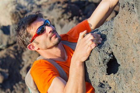 finger muscles - Young man in glasses with backpack climbing indoor wall. Stock Photo - Budget Royalty-Free & Subscription, Code: 400-05908083