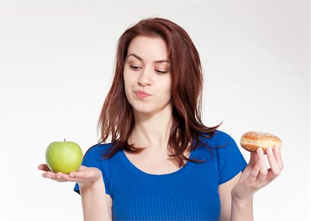 doughnut diet - Young woman choosing between an apple and a donut Stock Photo - Budget Royalty-Free & Subscription, Code: 400-05908320