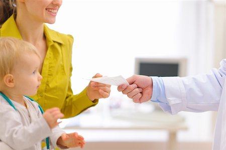 Closeup on pediatric doctors hand giving prescription to mother with baby Stock Photo - Budget Royalty-Free & Subscription, Code: 400-05908548