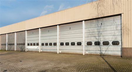 factory loading docks - industrial unit with old and damages roller shutter doors Stock Photo - Budget Royalty-Free & Subscription, Code: 400-05908594