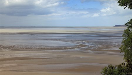 Landscape on Cuesnon river where is located the Mont Saint Michel Monastery in the north of France.The place is famous for some quite risky trekking routes at low tides through the very wet sand to places from where a very unusual perspective of the monastery can be seen. Foto de stock - Super Valor sin royalties y Suscripción, Código: 400-05909179