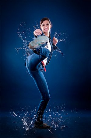 beautiful casual woman doing a kick on dark background Photographie de stock - Aubaine LD & Abonnement, Code: 400-05909457