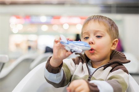 Cute little boy playing with a toy airplane in airport Foto de stock - Super Valor sin royalties y Suscripción, Código: 400-05909548