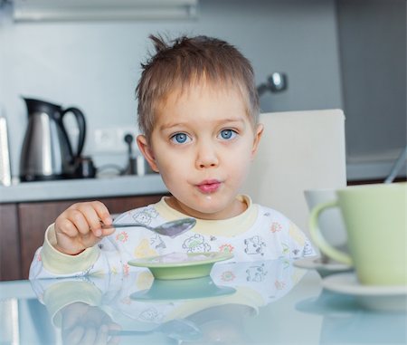 Happy little cute boy in pajamas eating breakfast at a table in the kitchen Stock Photo - Budget Royalty-Free & Subscription, Code: 400-05909876