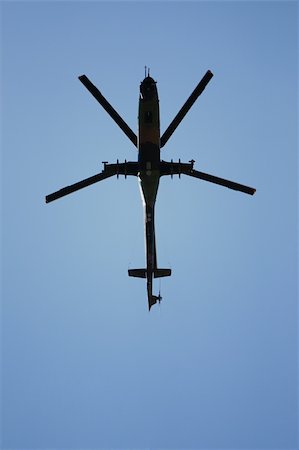 simsearch:673-02140713,k - Helicopter passing overhead isolated on blue sky Foto de stock - Royalty-Free Super Valor e Assinatura, Número: 400-05900163
