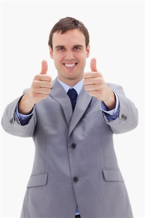 simsearch:400-04129711,k - Thumbs up given by smiling businessman against a white background Stock Photo - Budget Royalty-Free & Subscription, Code: 400-05900225