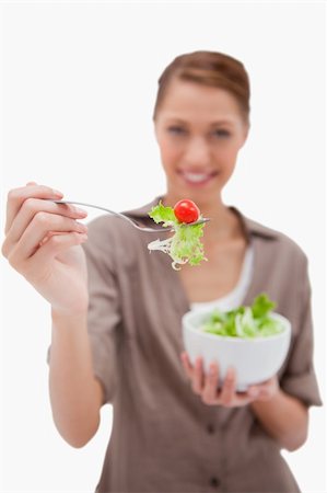 simsearch:400-05751129,k - Woman offering salad on a fork against a white background Stockbilder - Microstock & Abonnement, Bildnummer: 400-05900336
