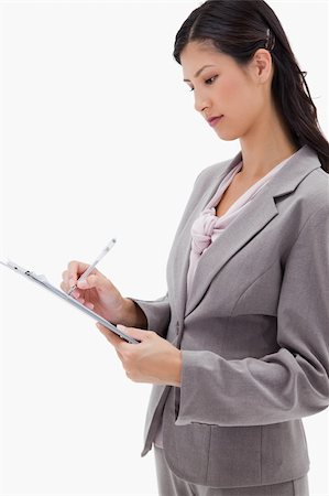 simsearch:400-06633122,k - Side view of businesswoman with clipboard against a white background Stock Photo - Budget Royalty-Free & Subscription, Code: 400-05900409