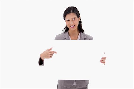 Smiling businesswoman pointing at blank sign board against a white background Stock Photo - Budget Royalty-Free & Subscription, Code: 400-05900454