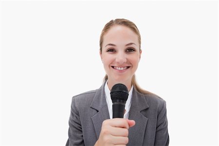 Smiling woman with microphone against a white background Stock Photo - Budget Royalty-Free & Subscription, Code: 400-05900525