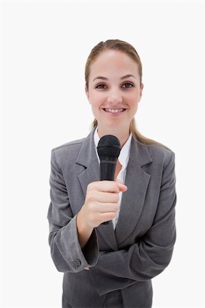 Smiling woman holding microphone against a white background Stock Photo - Budget Royalty-Free & Subscription, Code: 400-05900526