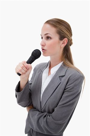 Side view of woman with microphone against a white background Foto de stock - Super Valor sin royalties y Suscripción, Código: 400-05900527