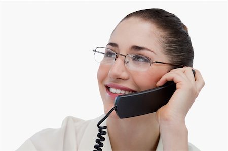 Close up of a smiling secretary making a phone call against a white background Stock Photo - Budget Royalty-Free & Subscription, Code: 400-05900633