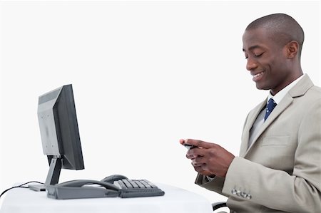 simsearch:400-05718346,k - Side view of a smiling businessman sending a text message against a white background Foto de stock - Super Valor sin royalties y Suscripción, Código: 400-05900688