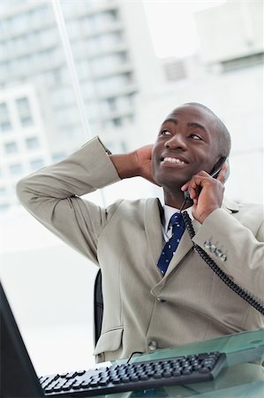 simsearch:400-06393704,k - Portrait of a relaxed office worker on the phone looking away from the camera Stock Photo - Budget Royalty-Free & Subscription, Code: 400-05900713