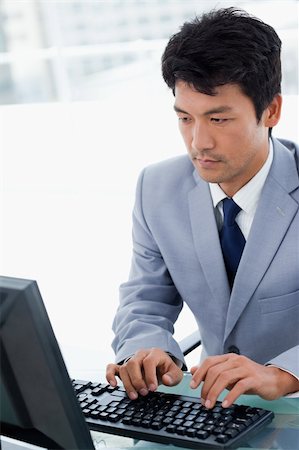 simsearch:400-05900668,k - Portrait of a serious manager using a computer in his office Stock Photo - Budget Royalty-Free & Subscription, Code: 400-05900778