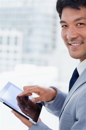 sales person with a tablet - Portrait of a smiling office worker using a tablet computer in his office Photographie de stock - Aubaine LD & Abonnement, Code: 400-05900772