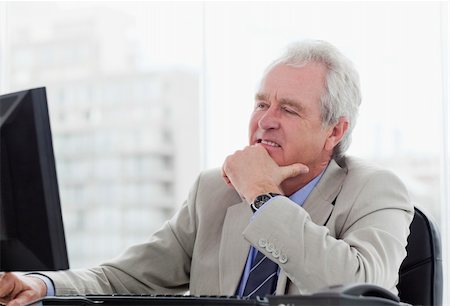 simsearch:400-04188055,k - Happy senior manager working with a monitor in his office Stock Photo - Budget Royalty-Free & Subscription, Code: 400-05900803