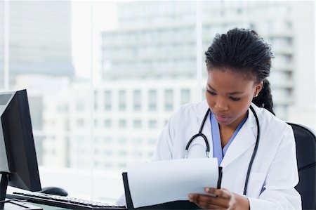 simsearch:400-06634198,k - Female doctor signing a document in her office Stock Photo - Budget Royalty-Free & Subscription, Code: 400-05900825