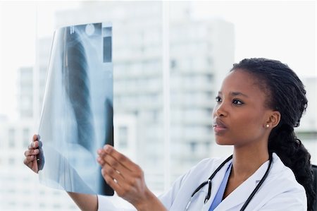 Female doctor looking at a set of X-rays in her office Stock Photo - Budget Royalty-Free & Subscription, Code: 400-05900826