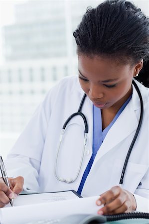 simsearch:400-06634198,k - Portrait of a female doctor signing a document in her office Stock Photo - Budget Royalty-Free & Subscription, Code: 400-05900822